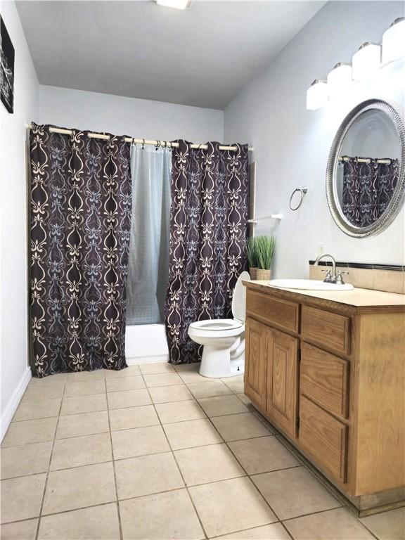 bathroom featuring vanity, a shower with curtain, toilet, and tile patterned floors