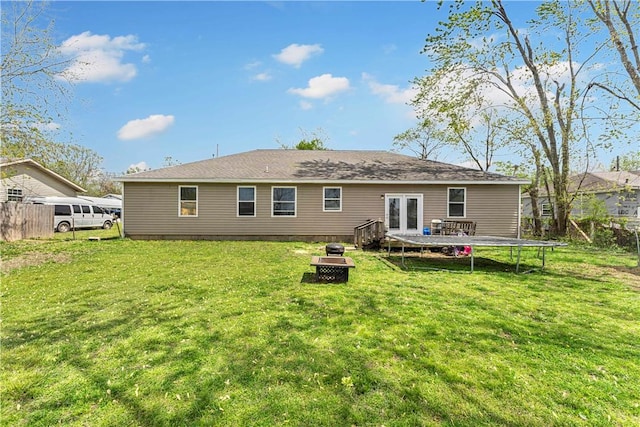 1408 N B St, Rogers, AR 72756 - rear view of house featuring a fire pit, a trampoline, a wooden deck, and french doors