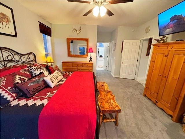 carpeted bedroom with ensuite bathroom and ceiling fan