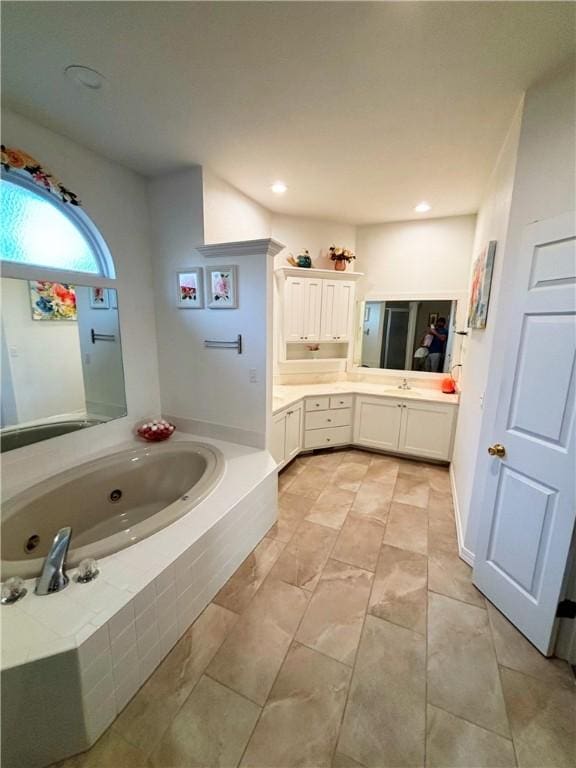 bathroom with a relaxing tiled tub and vanity