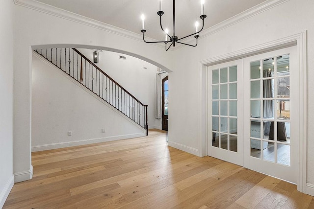 interior space with light hardwood / wood-style flooring, ornamental molding, and a chandelier