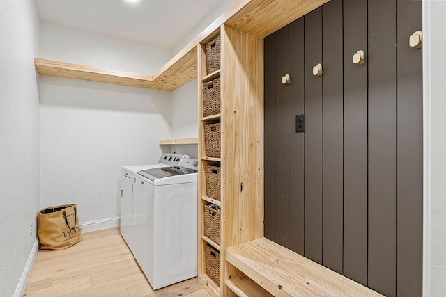 laundry room with washer and clothes dryer and light hardwood / wood-style flooring