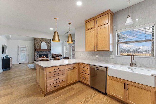 kitchen with sink, hanging light fixtures, light brown cabinets, dishwasher, and kitchen peninsula