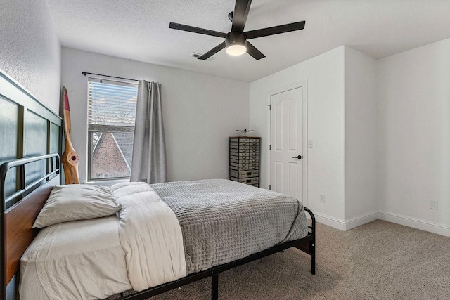 bedroom featuring ceiling fan, carpet, and a textured ceiling