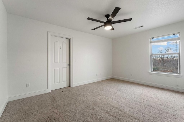 carpeted spare room with ceiling fan