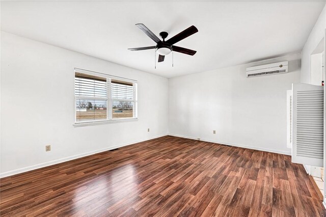 913 17th St, Rogers, AR 72758 - spare room with ceiling fan, an AC wall unit, and dark hardwood / wood-style flooring