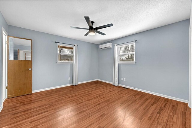 913 17th St, Rogers, AR 72758 - spare room featuring hardwood / wood-style flooring, ceiling fan, plenty of natural light, and a wall mounted AC