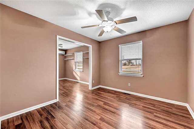 913 17th St, Rogers, AR 72758 - unfurnished room featuring hardwood / wood-style flooring, a wall mounted AC, a textured ceiling, and ceiling fan