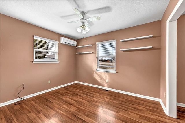 913 17th St, Rogers, AR 72758 - empty room featuring ceiling fan, a wall mounted air conditioner, hardwood / wood-style floors, and a textured ceiling