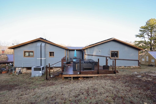 rear view of property with a wooden deck, a hot tub, and central air condition unit