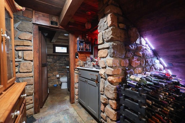 wine cellar featuring beam ceiling