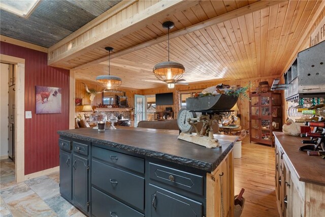 kitchen with pendant lighting, wood ceiling, light wood-type flooring, and wood walls