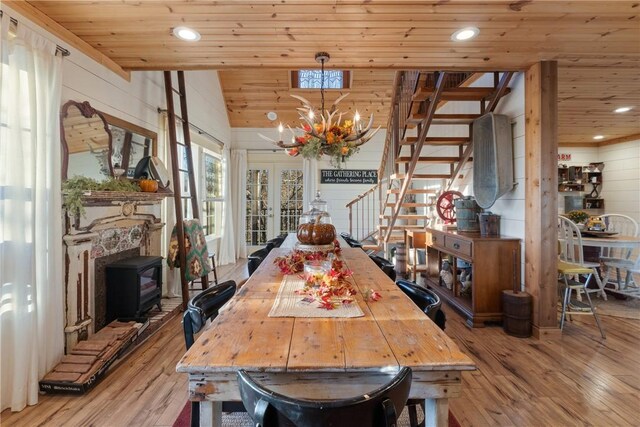 dining room featuring lofted ceiling, wooden ceiling, and light wood-type flooring