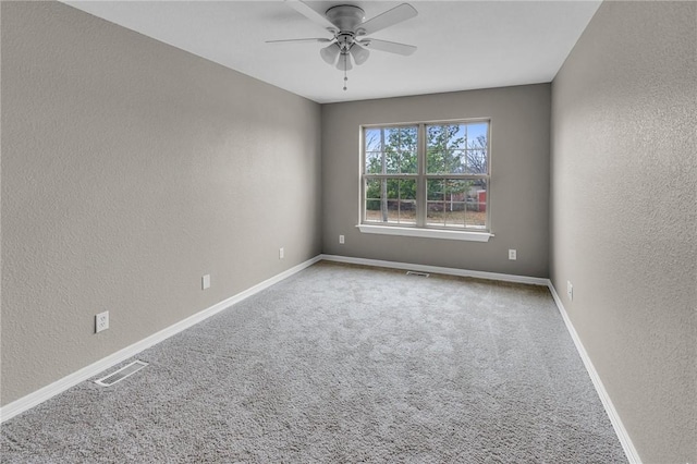 spare room with ceiling fan and carpet