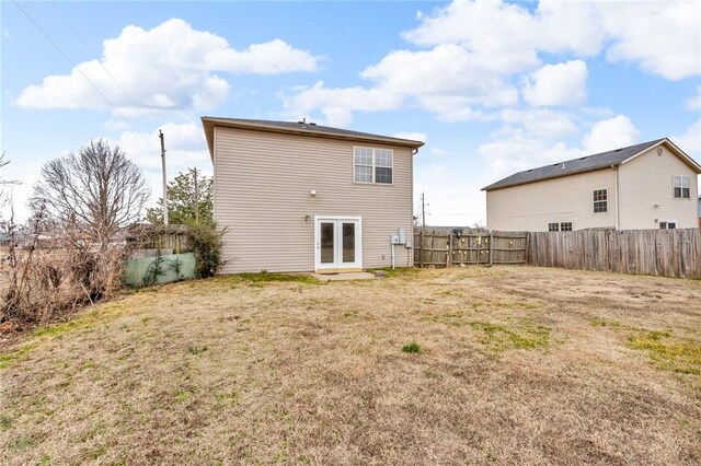 rear view of property featuring french doors and a lawn