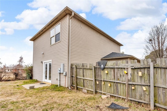 rear view of house with french doors and a yard