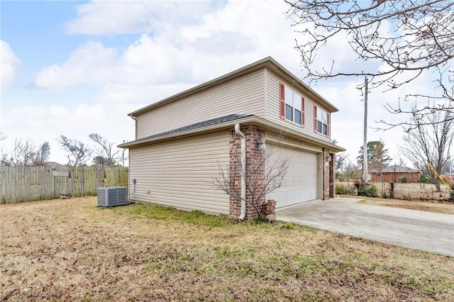 view of property exterior with a yard, a garage, and central air condition unit