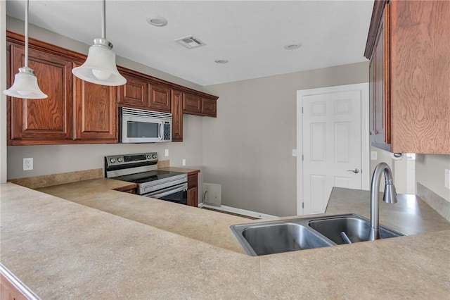 kitchen with pendant lighting, sink, and stainless steel appliances