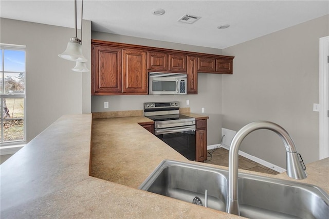 kitchen with sink, stainless steel appliances, and hanging light fixtures