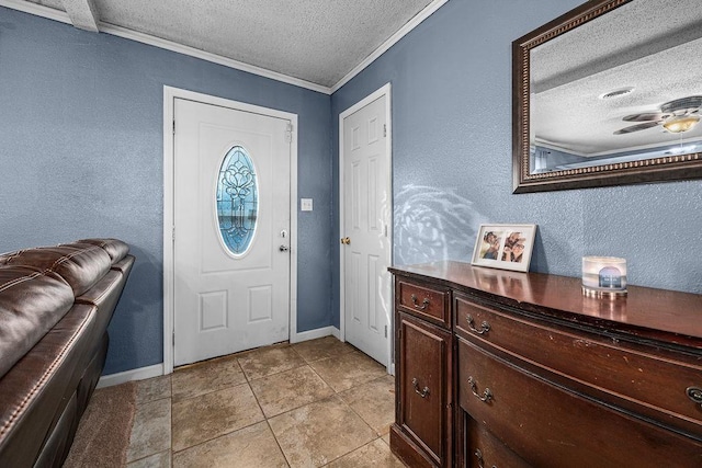 tiled entrance foyer featuring ceiling fan, crown molding, and a textured ceiling