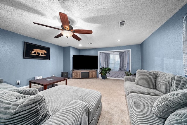 carpeted living room featuring a textured ceiling and ceiling fan