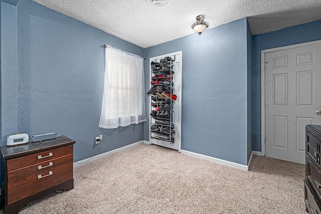 carpeted bedroom with a closet and a textured ceiling