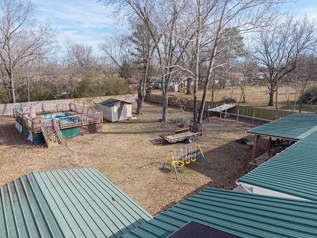 view of yard featuring a pool and a shed