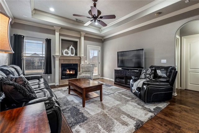 living room featuring a raised ceiling, a wealth of natural light, and dark hardwood / wood-style flooring