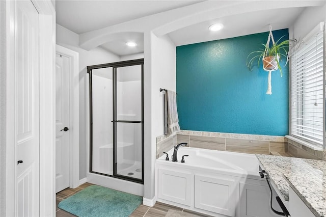 bathroom featuring hardwood / wood-style flooring, vanity, and shower with separate bathtub