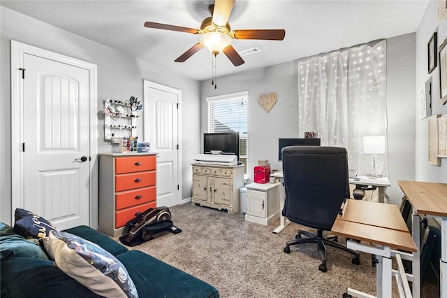 carpeted home office featuring ceiling fan