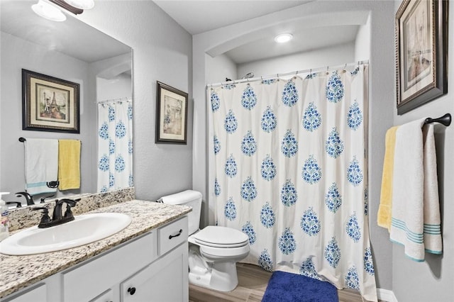 bathroom with vanity, curtained shower, wood-type flooring, and toilet