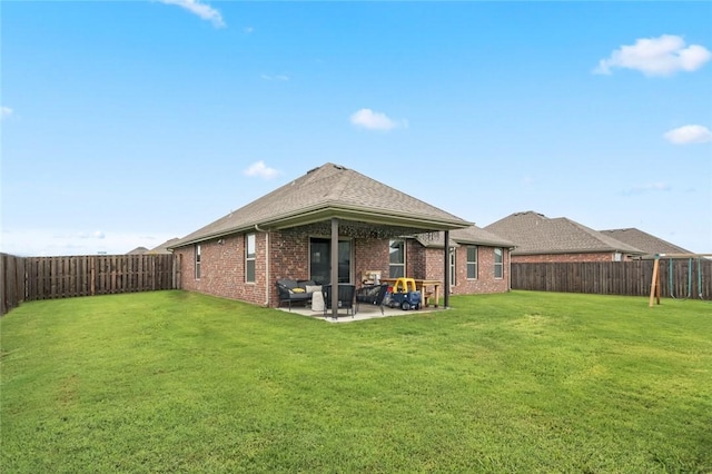 rear view of property featuring a yard and a patio area