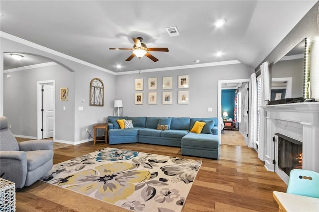 living room featuring ornamental molding, vaulted ceiling, ceiling fan, and light hardwood / wood-style flooring