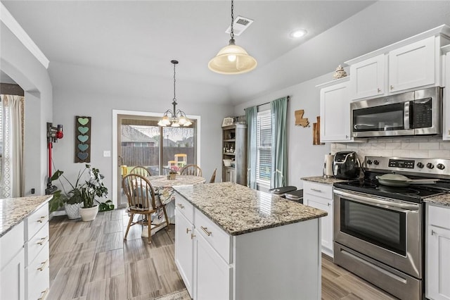 kitchen featuring appliances with stainless steel finishes, a center island, pendant lighting, and white cabinets