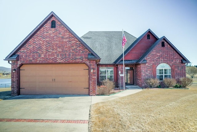 view of front facade featuring driveway, brick siding, and an attached garage