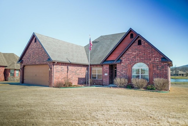 view of front of house with an attached garage, a front lawn, and brick siding