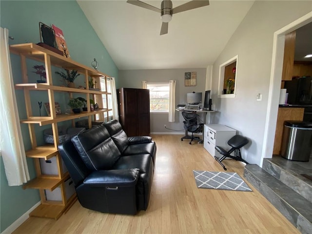 living room featuring ceiling fan, vaulted ceiling, and light wood-type flooring