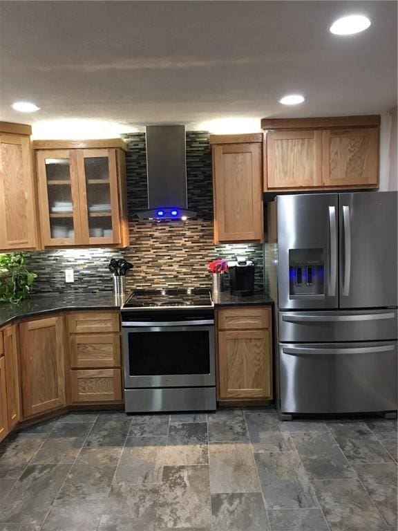 kitchen featuring appliances with stainless steel finishes, wall chimney range hood, and backsplash