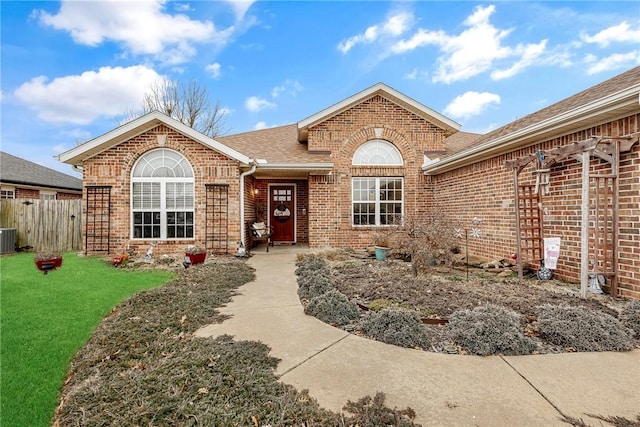 view of front of house featuring central AC unit and a front lawn