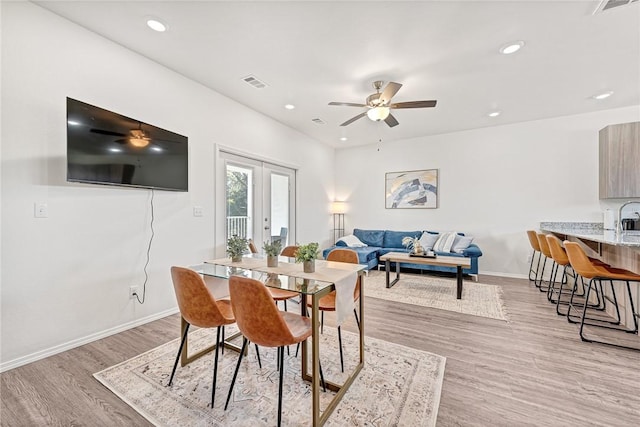 dining space with french doors, ceiling fan, and light hardwood / wood-style flooring