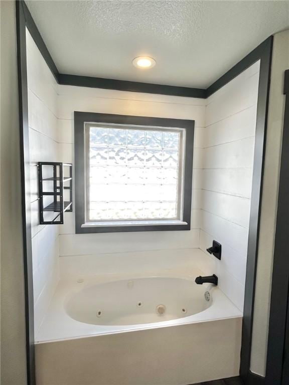 bathroom featuring a bath and a textured ceiling