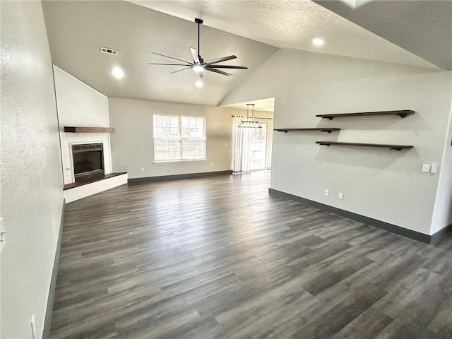 unfurnished living room with high vaulted ceiling, dark hardwood / wood-style flooring, a tiled fireplace, ceiling fan, and a textured ceiling