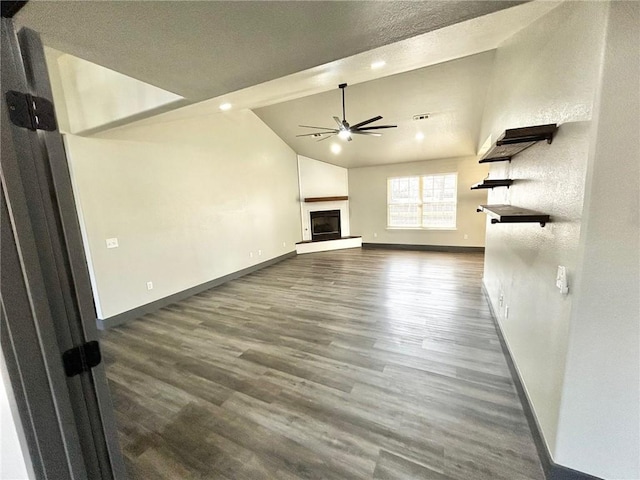 unfurnished living room with vaulted ceiling, dark hardwood / wood-style floors, and ceiling fan