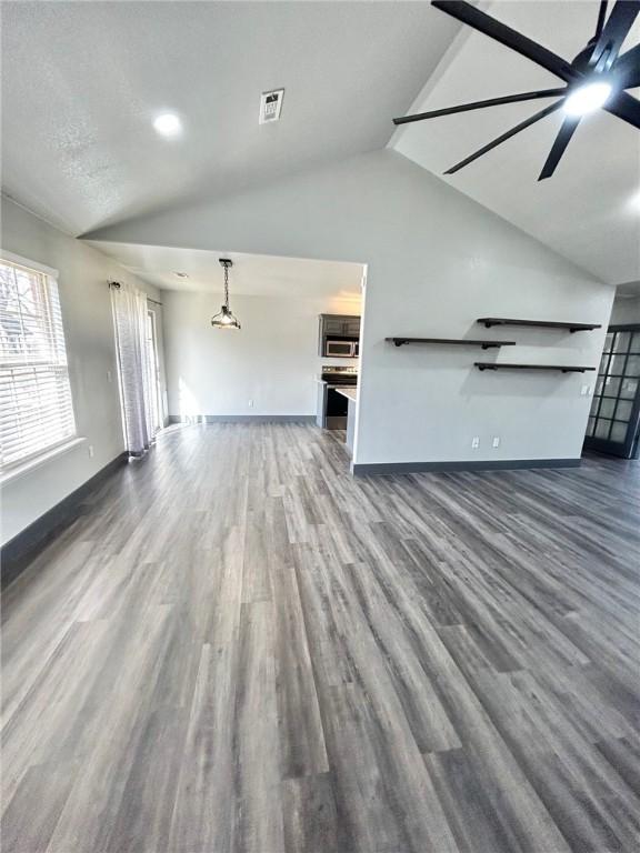 unfurnished living room with ceiling fan, lofted ceiling, and dark hardwood / wood-style floors