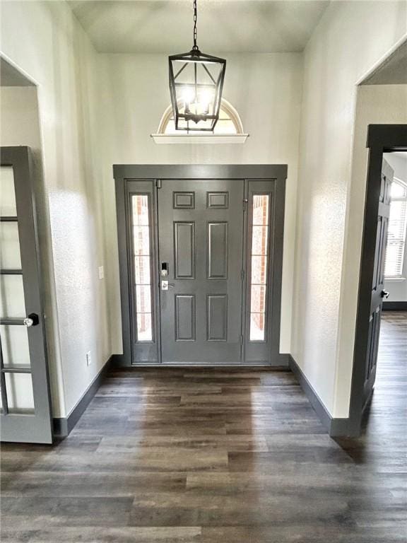 foyer entrance with dark wood-type flooring and a chandelier