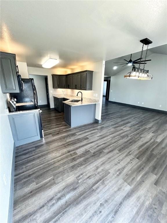 kitchen featuring hanging light fixtures, lofted ceiling, sink, and dark hardwood / wood-style floors