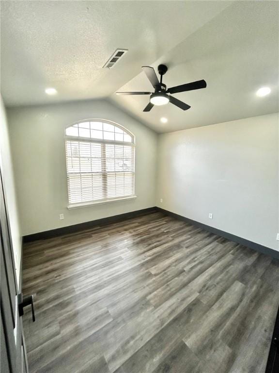 unfurnished room with lofted ceiling, ceiling fan, dark hardwood / wood-style floors, and a textured ceiling