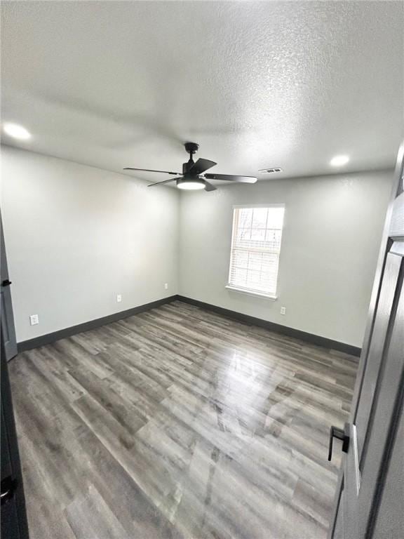 spare room with ceiling fan, hardwood / wood-style floors, and a textured ceiling