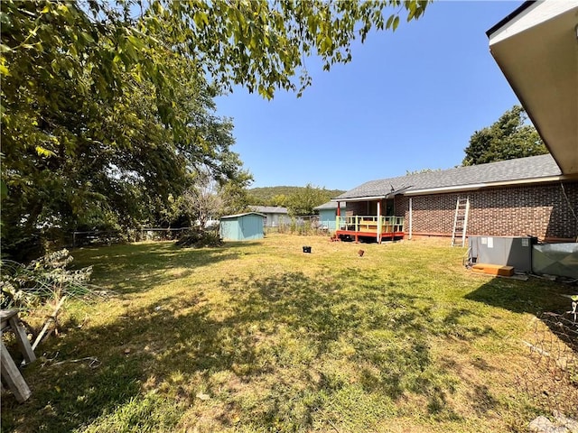 view of yard featuring a deck and a shed