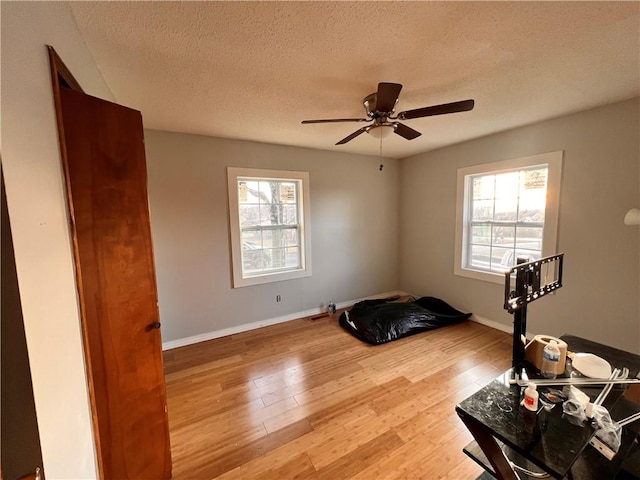 interior space featuring hardwood / wood-style flooring, ceiling fan, and a textured ceiling